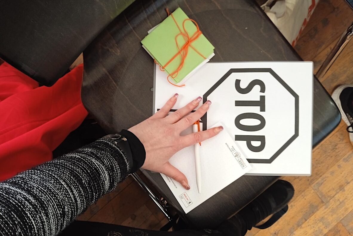 Eine Hand liegt auf einem Stop-Schild auf Papier.
